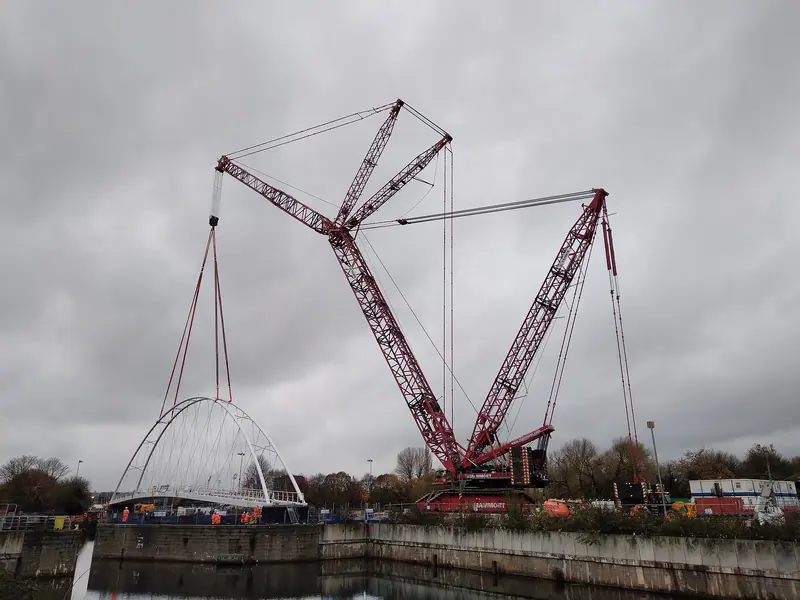Crawler crane lifting a steel bridge span into place